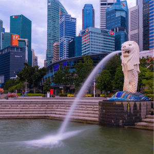 Merlion statue with water flowing from the mouth in the river in Singapore