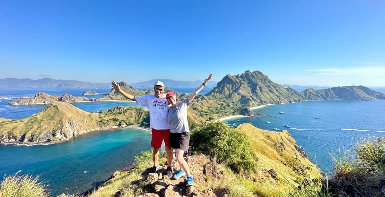 john and Bev retirement travelers standing on the top of Padar island with views of water and islands