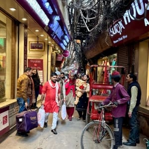 street with bicycles, shoppers and stores in Delhi