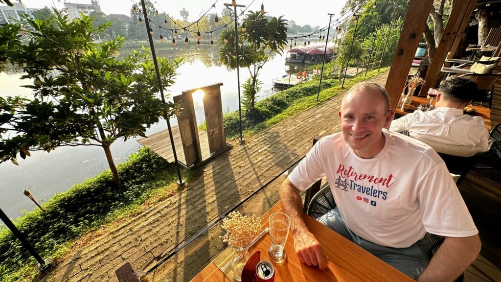 man sitting at restaurant beside river in Chiang Mai