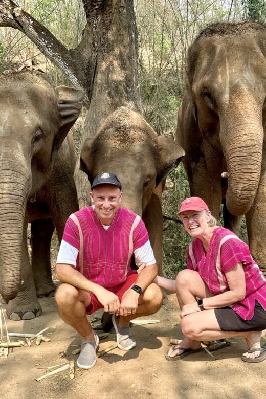 John and Bev retirement travelers with elephant family in Chiang Mai