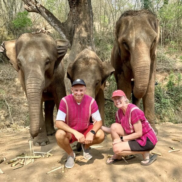John and Bev retirement travelers with elephant family in Chiang Mai