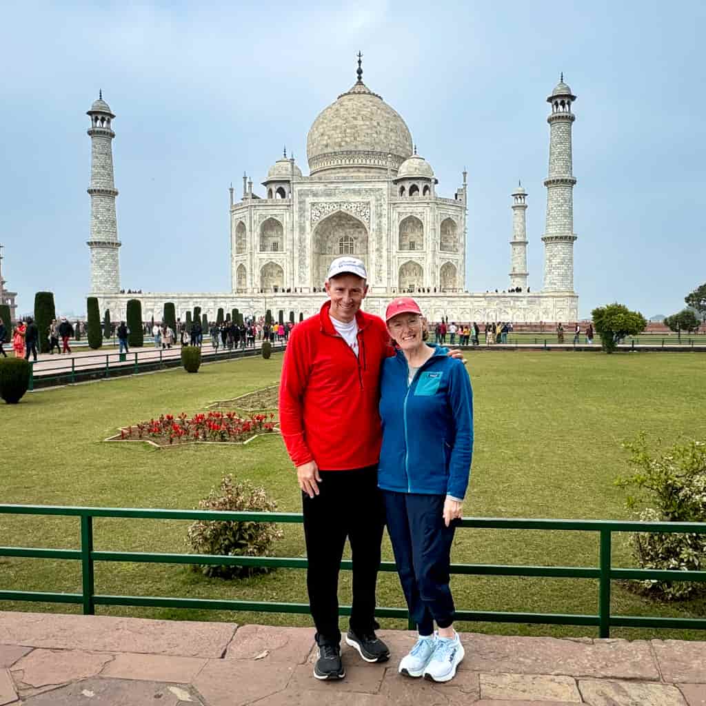 John and Bev, Retirement Travelers, standing in front of Taj Mahal.
