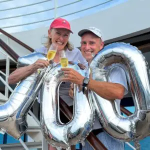 A picture of John & Bev celebrating 100 countries with balloons and champaign.