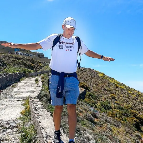 man walking on a stone wall in Santorini