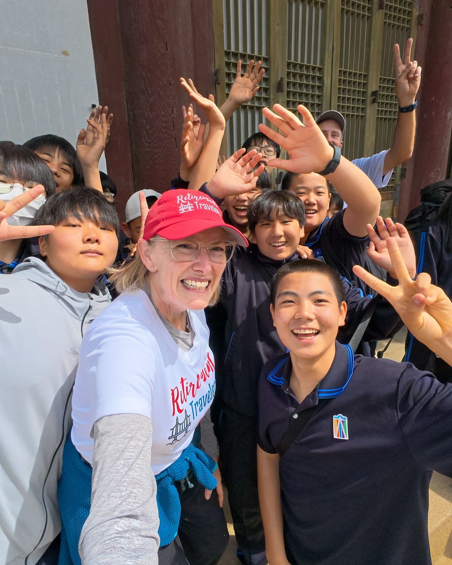 One thing we learned in Seoul today is that by wearing our Retirement Travelers shirts and vlogging our adventures, we were no longer ordinary tourists. We were viral-worthy legends in the eyes of middle-school boys. At Gyeongbokgung Palace, we were admiring the royal rooftops when this fun group of kids spotted us and swarmed. Phones clicked, peace signs flew, and we soaked up our five minutes of fame. And to think—our kids back home just call us “cute old people” but clearly, in South Korea, we are one step away from debuting as the next K-pop duo. 🤣 #seoulkorea #seoul🇰🇷 #kpop #korea NEVER STOP ACTING LIKE A KID!!!