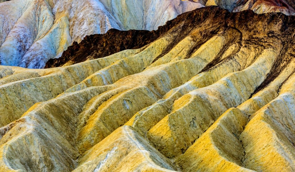 colorful yellow rock formations in death valley