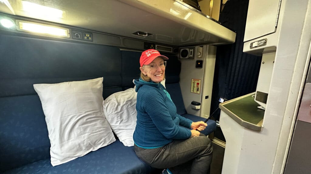 Bev sitting on the bed of an Amtrak sleeper car